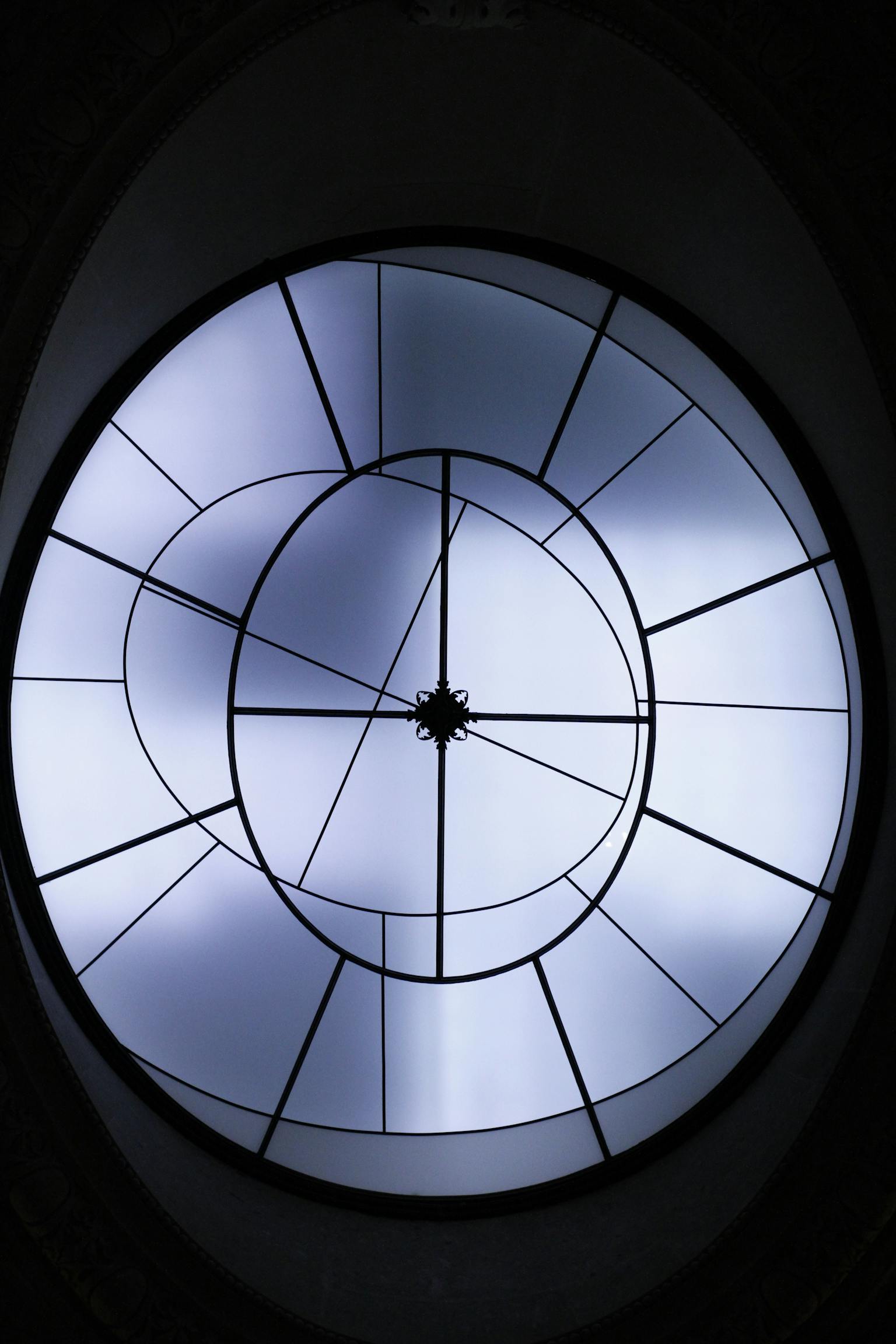 Futuristic circular skylight with geometric design and light patterns.